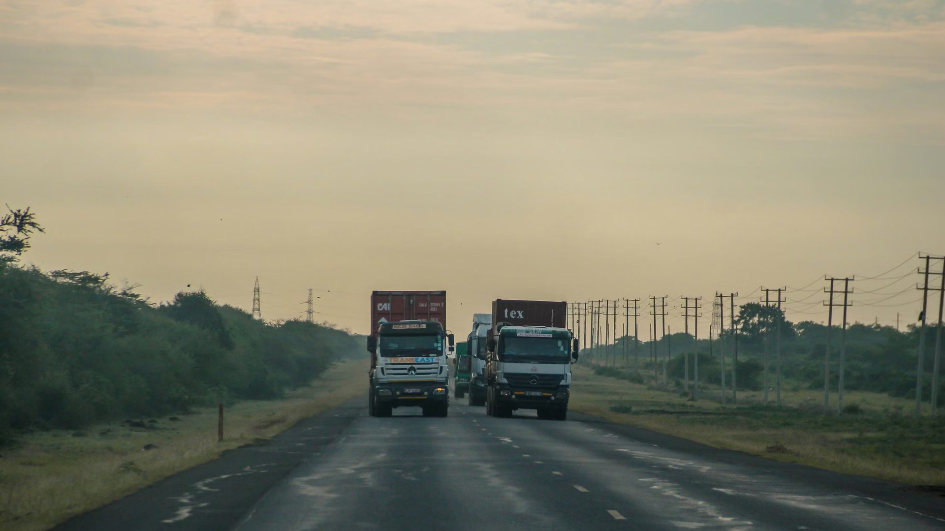 Container trucks on an East African highway at dawn